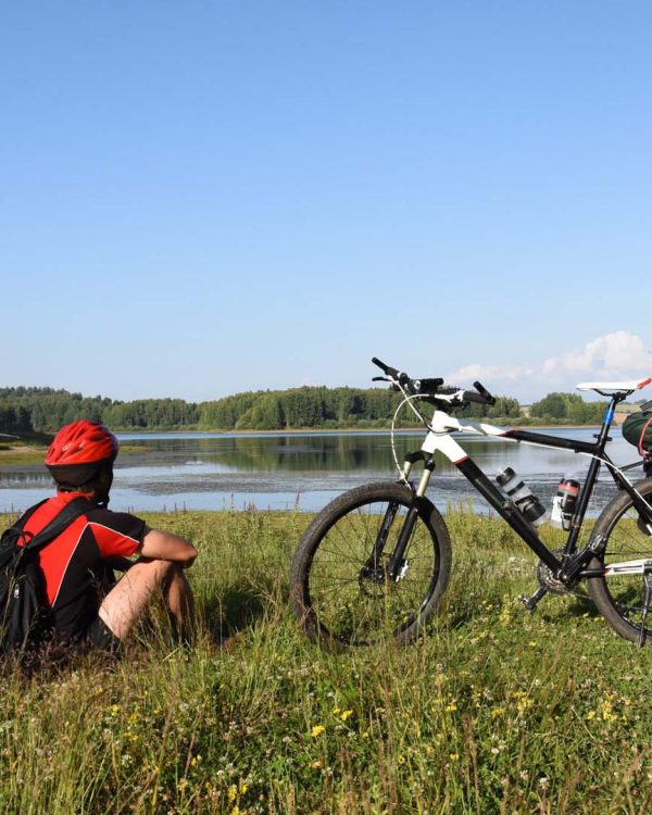 mountain bike rider relaxing near a lake